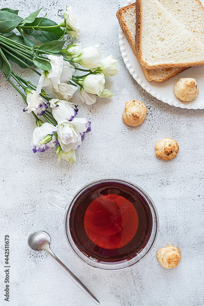 Top view of a breakfast with a cup of tea, cookies, bread and flowers Top view of a breakfast with a cup of tea, cookies, bread and flowers