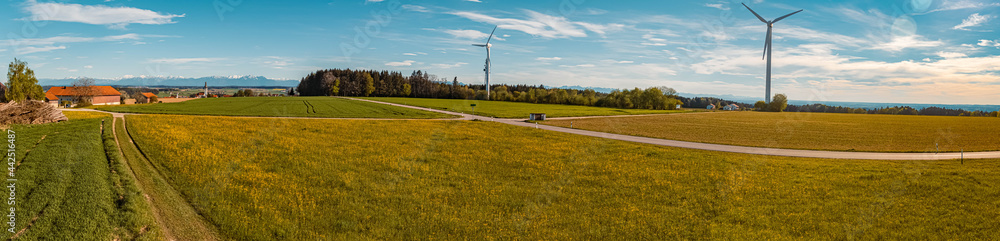 High resolution stitched panorama of a beautiful spring view on a sunny day with wind power plants and the alps in the background near Schnaitsee, Bavaria, Germany
