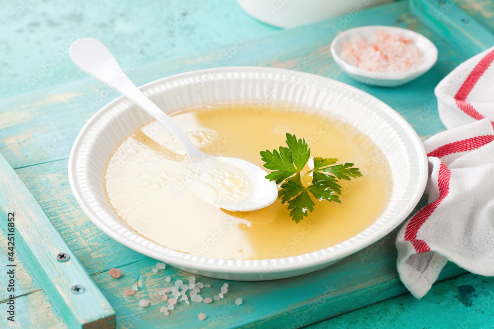 Chicken broth from organic farm poultry in white bowl, selective focus Chicken broth from organic farm poultry in white bowl, selective focus