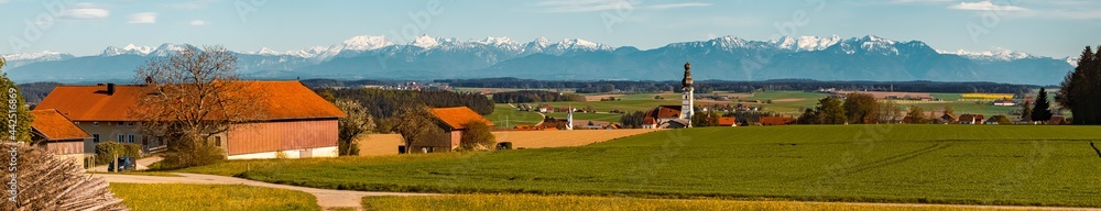 High resolution stitched panorama of a beautiful spring view on a sunny day with a church and the alps in the background near Schnaitsee, Bavaria, Germany