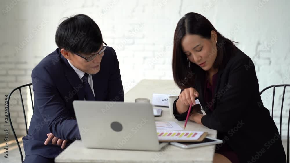 asian businessman and businesswoman using laptop computer discussion in meeting together at office . two worker talking and training to working. teamwork advice asian businessman and businesswoman using laptop computer discussion in meeting together at office . two worker talking and training to working. teamwork advice