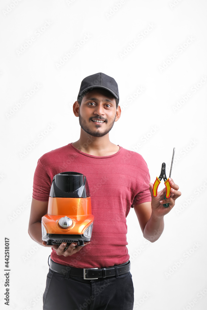 Young indian man who repair electronics kitchenware holding tools and mixer in hand