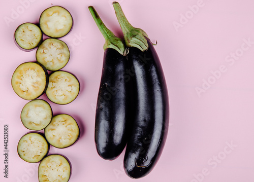 top view of  fresh eggplant with chopped slices on pink background