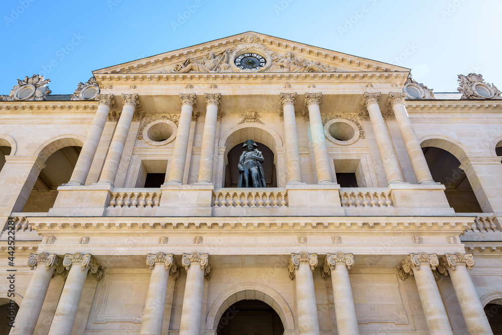 Low angle view of the southern facade of the court of honor of the Hotel des Invalides in Paris, France, with the statue of Napoleon Bonaparte on the balcony