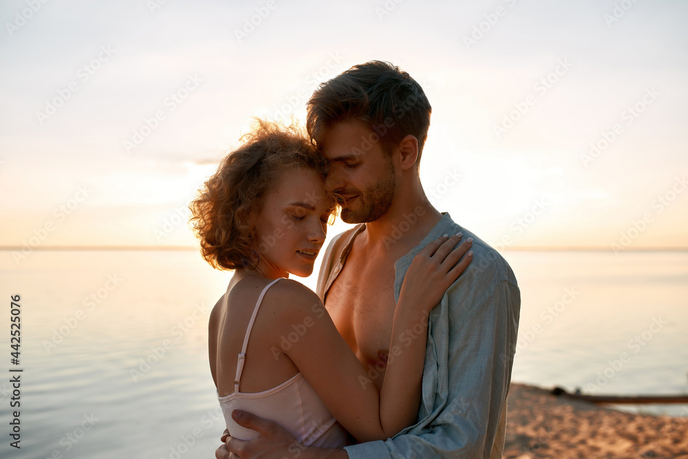 Beautiful young caucasian lovers hugging at sunset Beautiful young caucasian lovers hugging at sunset