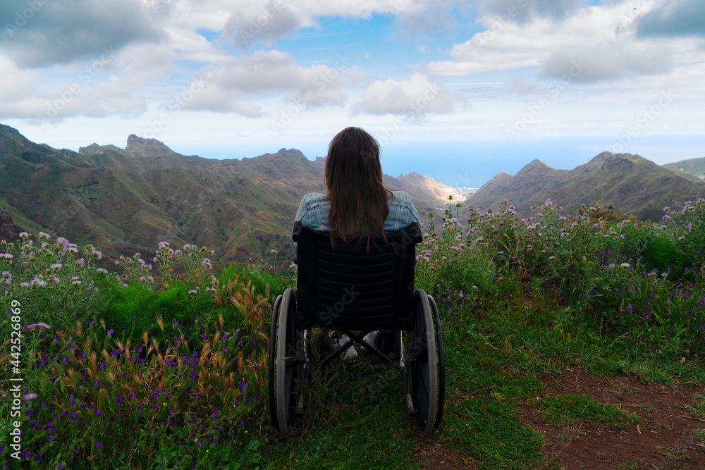 Disabled handicapped woman in wheelchair on mountain hill enjoying view Disabled handicapped woman in wheelchair on mountain hill enjoying view