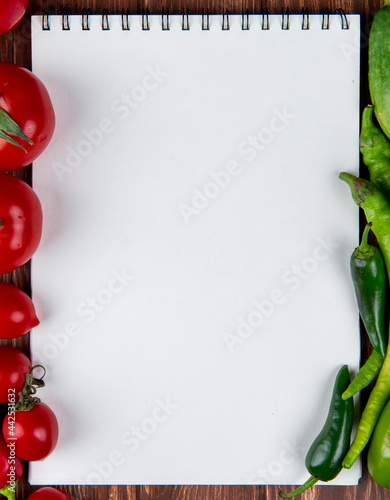 top view of fresh vegetables ripe tomatoes red and green chili peppers cucumbers and green bell peppers on rustic background