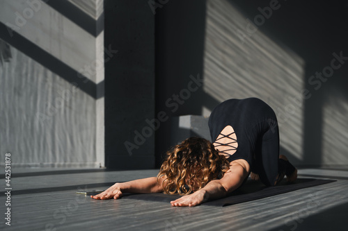 Young woman practicing yoga poses in an urban background on sunny day