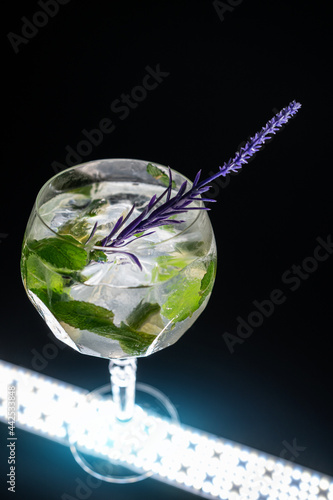 cocktail hugo or mojito with mint, lime and ice in wineglass on black background