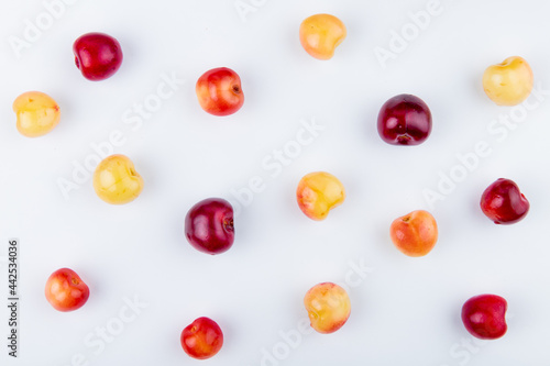 top view of ripe red and yellow cherries isolated on white background