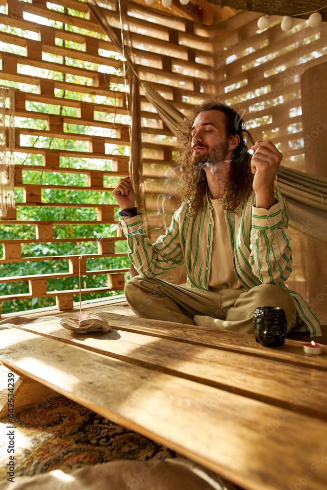 side view of a young hippie smelling balms with eyes closed side view of a young hippie smelling balms with eyes closed