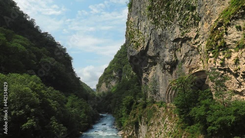 Mountain gorge filmed in time laps. High rocks around. The clear Shakhe River in Sochi, Russia, flows between sheer cliffs. Calm mountain landscape.