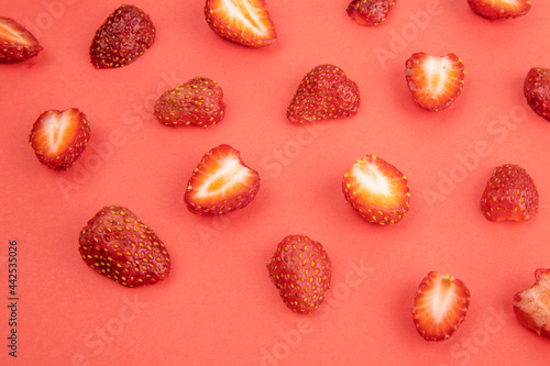 top view of sliced strawberries on red background