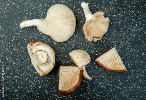 top view of whole and sliced fresh mushrooms isolated on dark background