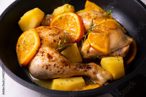 Chicken cooked with potatoes and orange sauce.