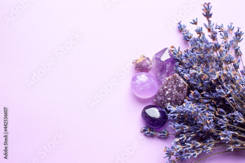 Beautiful amethyst crystals and round rose quartz stone with dry lavender bouquet. Magic amulets. Copy space photo