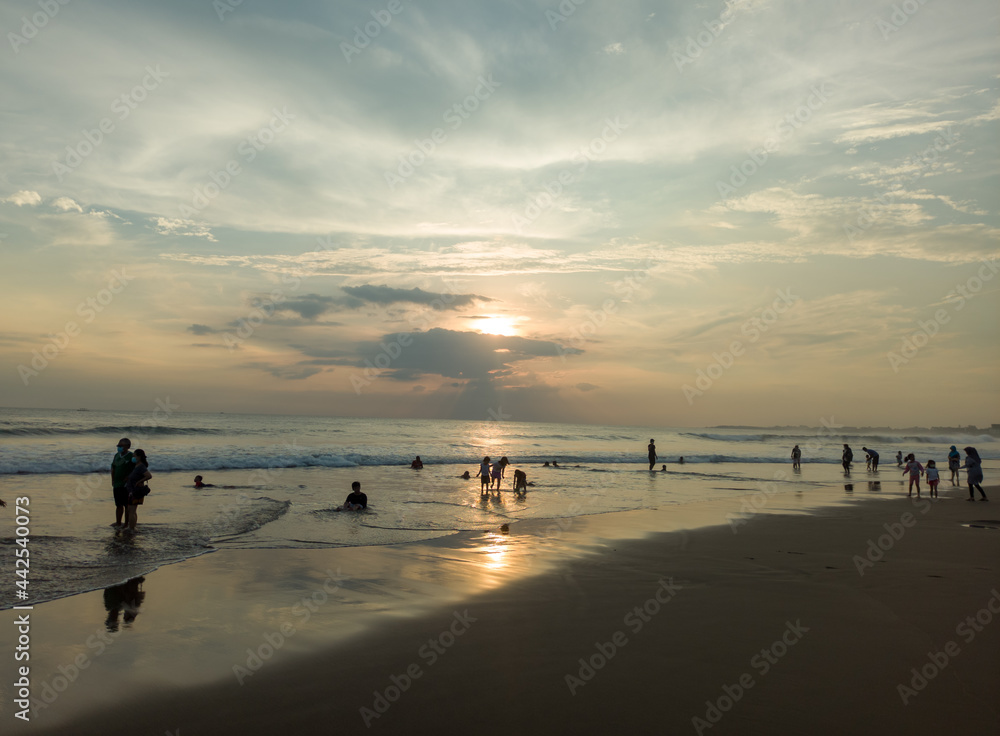 reflection of sunlight and shadows of people on petitenget beach, kerobokan, bali