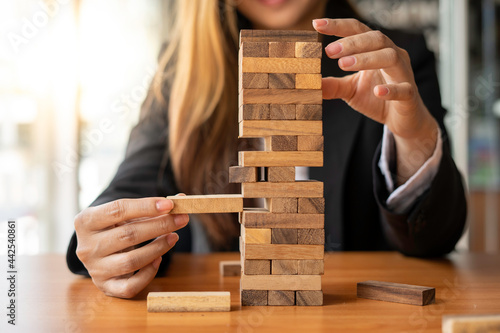 Fotografia A businesswoman pulls a wooden block in the middle of the floor