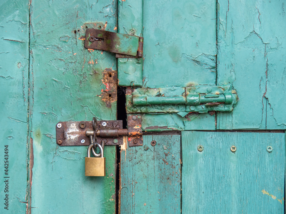 Vintage security, ancient bolts and a padlock close this old door.