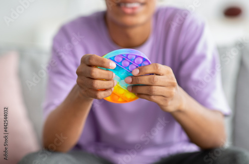 Canvastavla Closeup view of African American teenager playing with antistress POP IT toy at