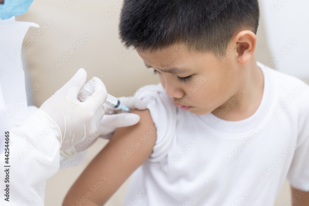 Doctor vaccinating Asian little boy at doctor's office Doctor vaccinating Asian little boy at doctor's office