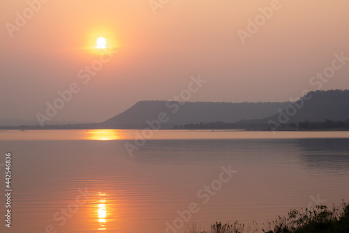 The golden light of the evening setting sun and reflections on the water surface.