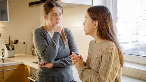 Young mother listening and talking to her teenage daughter complaining about problems and depression. Parent supporting and comforting child