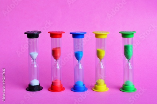Colorful hour sandglass on pink background
