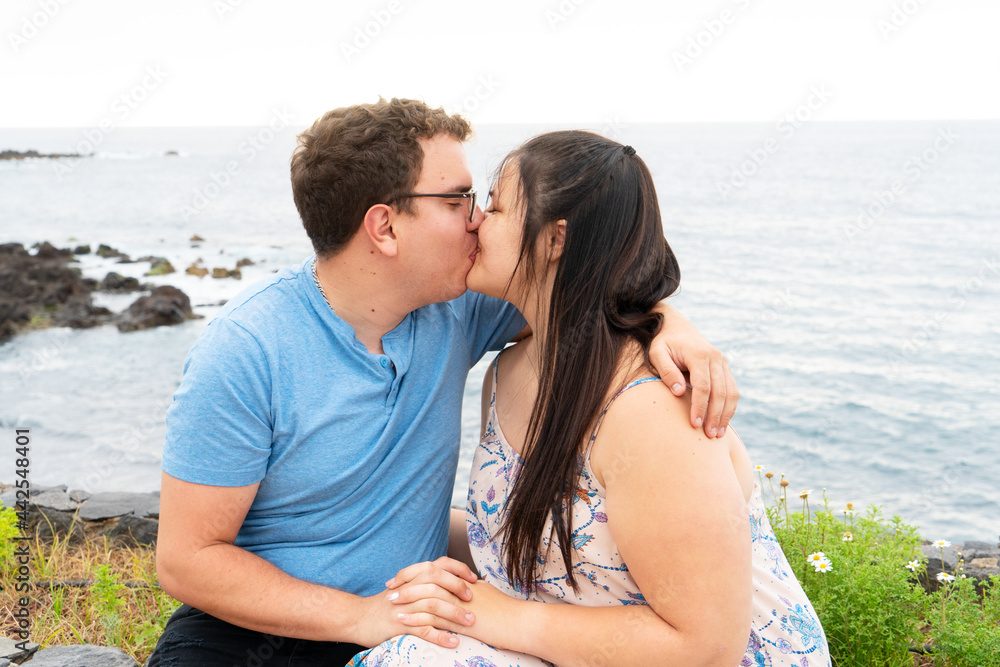 couple in love kissing each other while spending time outdoors on seaside couple in love kissing each other while spending time outdoors on seaside
