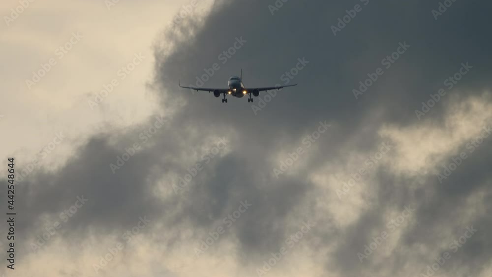 Airplane landing on the background of the cloudy sky Airplane landing on the background of the cloudy sky
