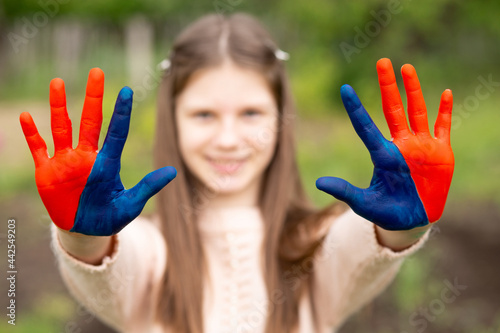Hands of kid girl painted in Mongolia flag color. Focus on hands. July 10 National Flag Day. Mongolian memorial holiday 29th of December 