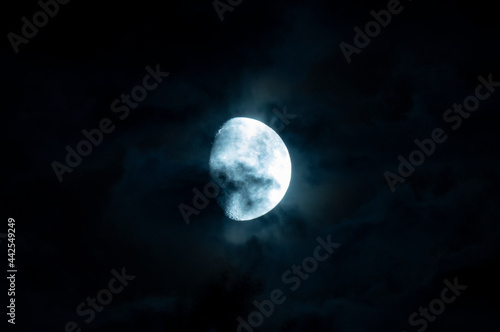Clouds and spots on the moon. Moonlight in the black night sky