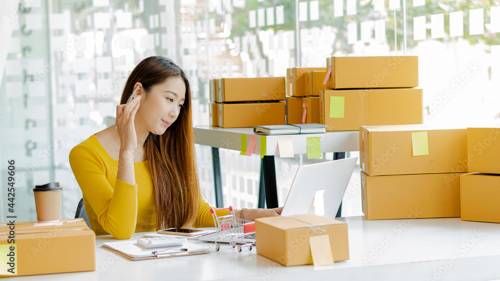 Start small business SME freelancer Portrait of young Asian woman working from home Box Smartphone Laptop Online Marketing Packaging Concept Shipping ParcelSME E-commerce Concept Start small business SME freelancer Portrait of young Asian woman working from home Box Smartphone Laptop Online Marketing Packaging Concept Shipping ParcelSME E-commerce Concept