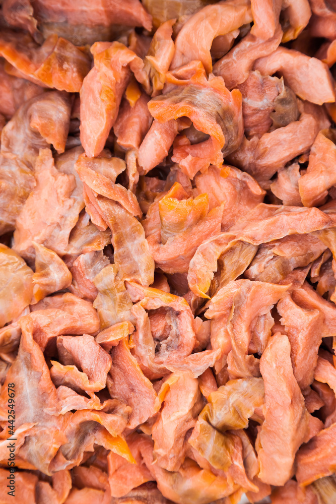 Lots of pieces of salted, finely chopped, red fish, close-up. Lots of pieces of salted, finely chopped, red fish, close-up.