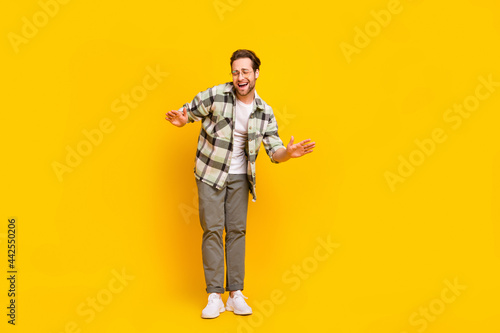 Full size photo of young excited man happy positive smile enjoy music dance club isolated over yellow color background