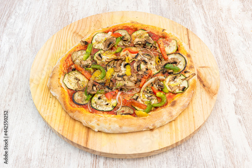 Great vegan pizza with many kinds of vegetables and mushrooms with wheat flour dough on wooden board