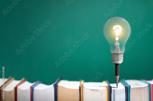 Lamp bulb on pencil  on book idea concept.