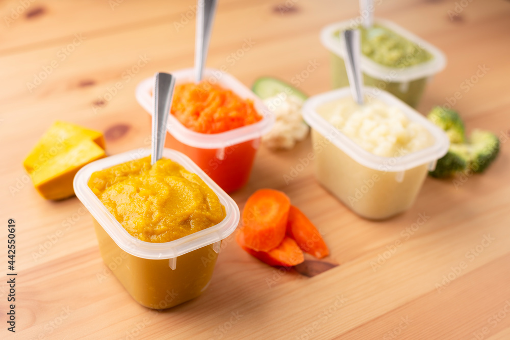 Close up of bowls with healthy baby food on wooden background..Pureed baby food make by carrot, broccoli and pumpkin
