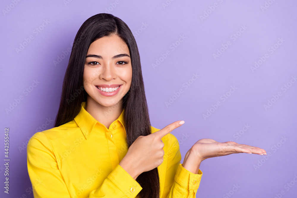 Photo of cute brown hairdo young millennial lady hold point empty space wear yellow shirt isolated on purple background Photo of cute brown hairdo young millennial lady hold point empty space wear yellow shirt isolated on purple background