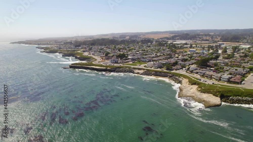 Long aerial drone shot of small town along the ocean. 