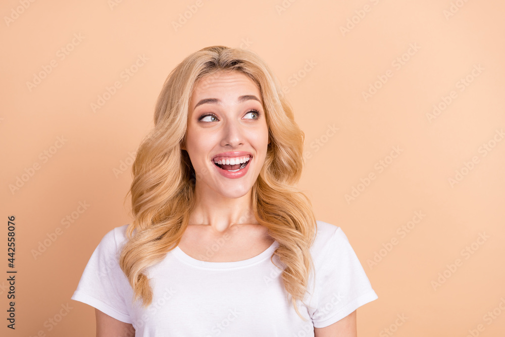 Photo of sweet charming young lady wear white t-shirt smiling looking empty space isolated beige color background Photo of sweet charming young lady wear white t-shirt smiling looking empty space isolated beige color background