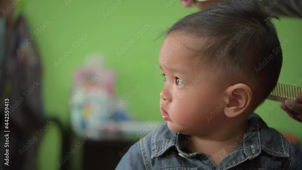 Asian Toddler child getting his first haircut. Asian Toddler child getting his first haircut.
