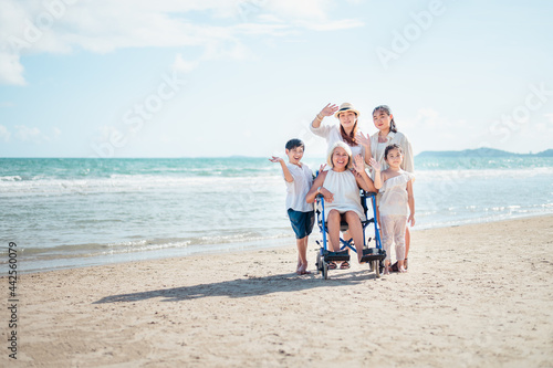 Family happily chatted with Grandma on the beach wheelchair.