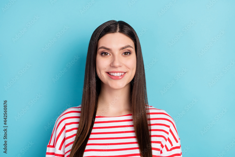 Portrait of attractive cheerful long-haired girl freelancer wearing striped pullover isolated over bright blue color background Portrait of attractive cheerful long-haired girl freelancer wearing striped pullover isolated over bright blue color background