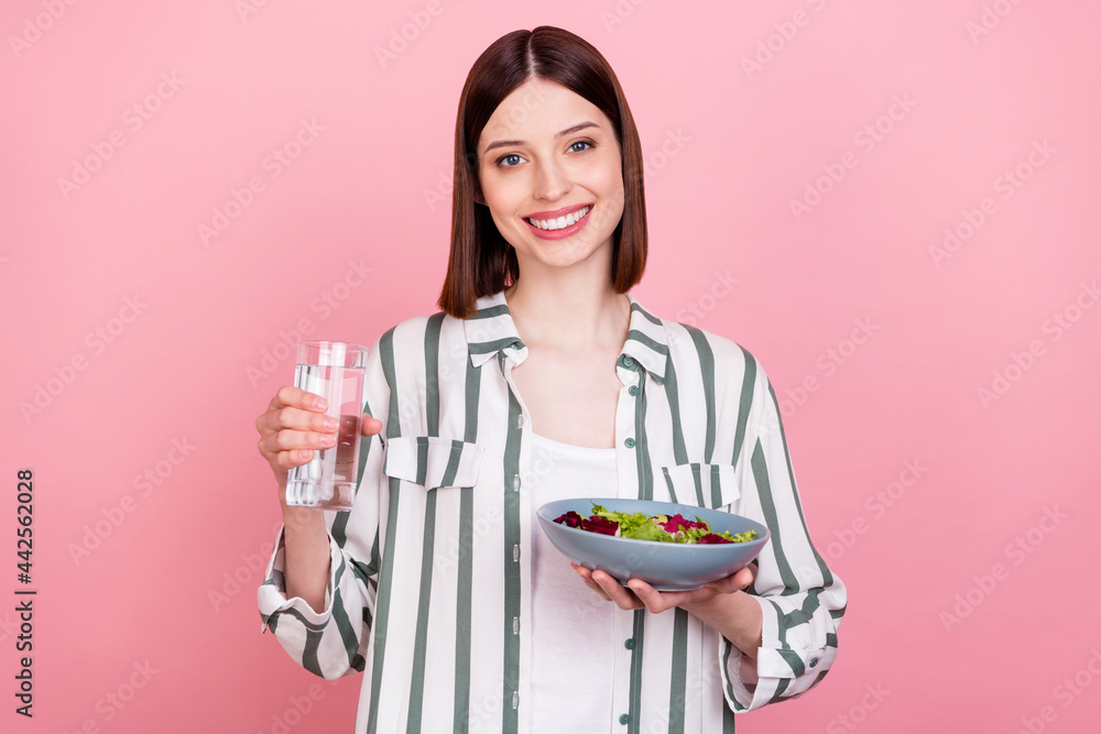 Photo of young girl happy positive smile lunch drink water eat eco vegetables bowl isolated over pastel color background Photo of young girl happy positive smile lunch drink water eat eco vegetables bowl isolated over pastel color background