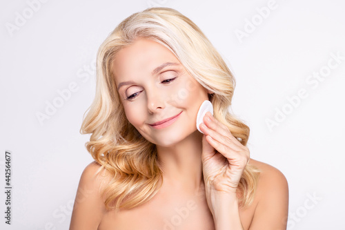 Portrait of attractive nude woman using cotton pad moisturizing clean isolated over white color background