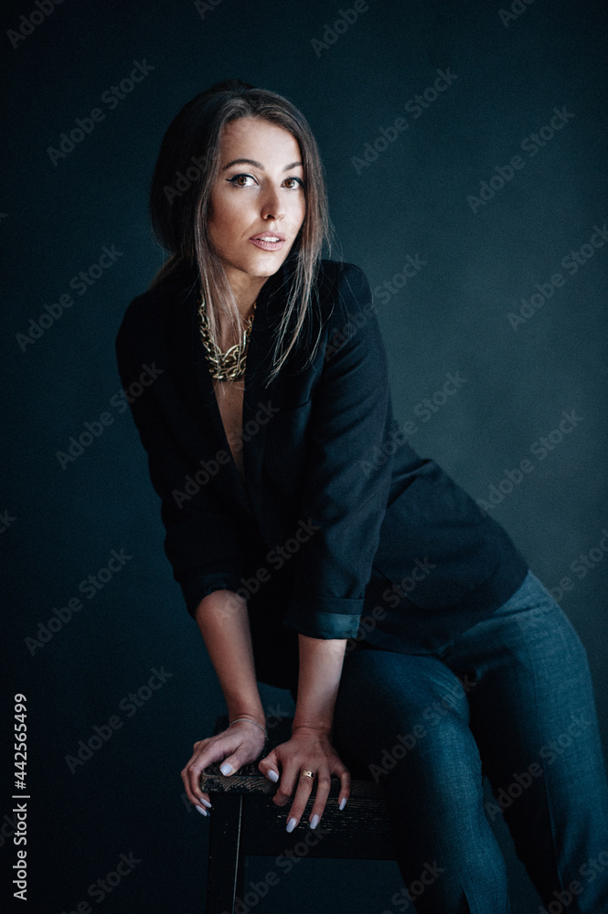 Beautiful woman sits on a chair and looks at you Beautiful woman sits on a chair and looks at you