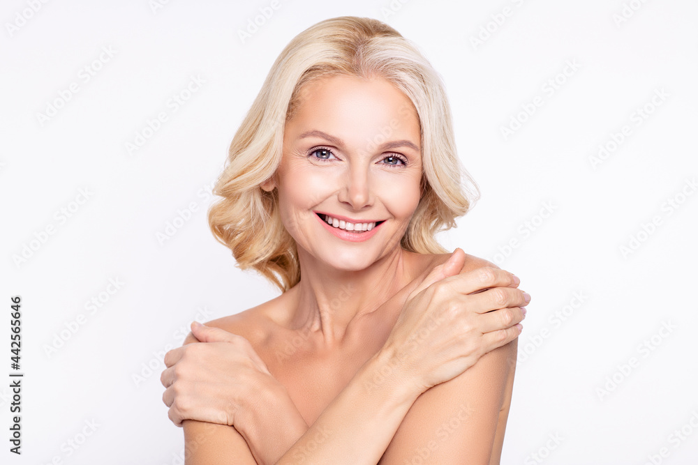 Portrait of attractive dreamy healthy grey-haired woman touching shoulders domestic wellbeing isolated over white color background Portrait of attractive dreamy healthy grey-haired woman touching shoulders domestic wellbeing isolated over white color background