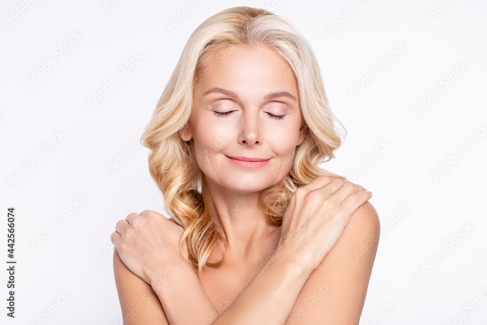 Portrait of attractive cheery healthy grey-haired woman hugging shoulders delicate smoothing isolated over white color background Portrait of attractive cheery healthy grey-haired woman hugging shoulders delicate smoothing isolated over white color background