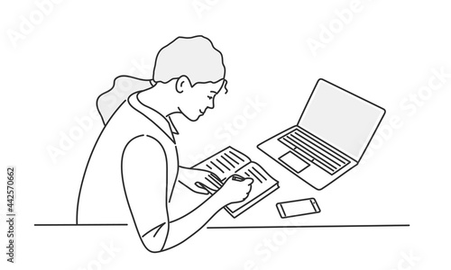 Young woman sitting behind work table and writing.